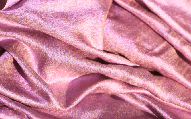A close up image of shiny pink fabric.