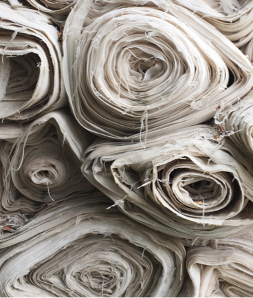 The ends of fabric rolls piled on top of each other.
